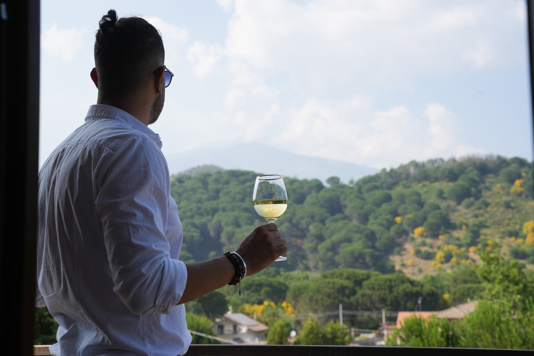 Un calice di vino bianco sulla terrazza, davanti alle colline verdi