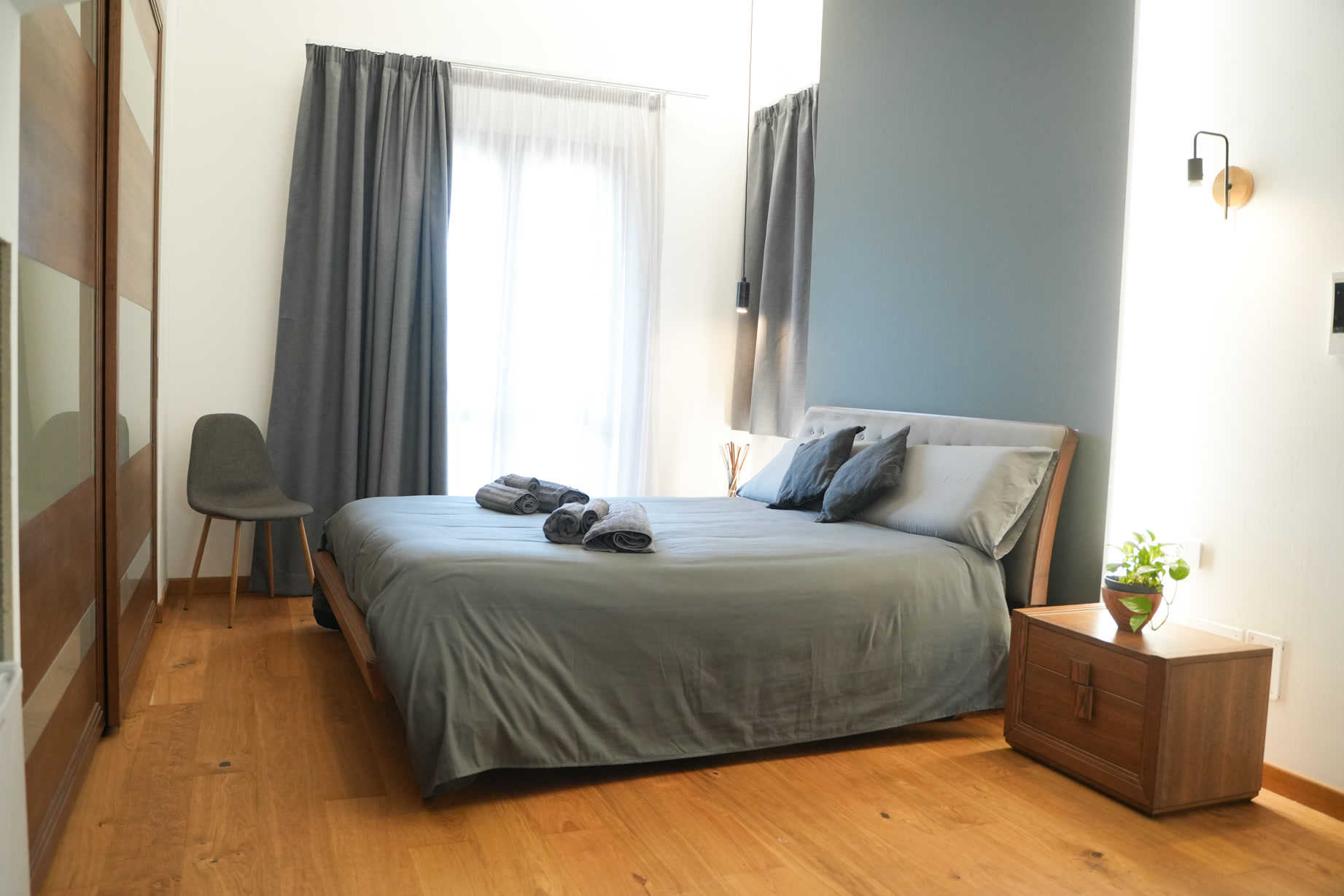 La camera vista dall'ingresso: letto, sedia e luce dalla finestra