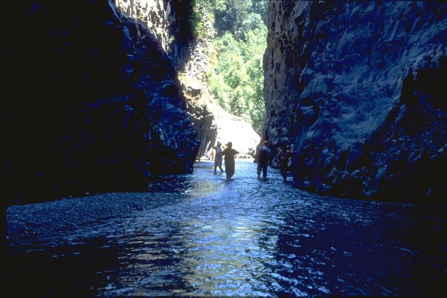 Le pareti di basalto delle gole, escursionisti in acqua nella luce blu
