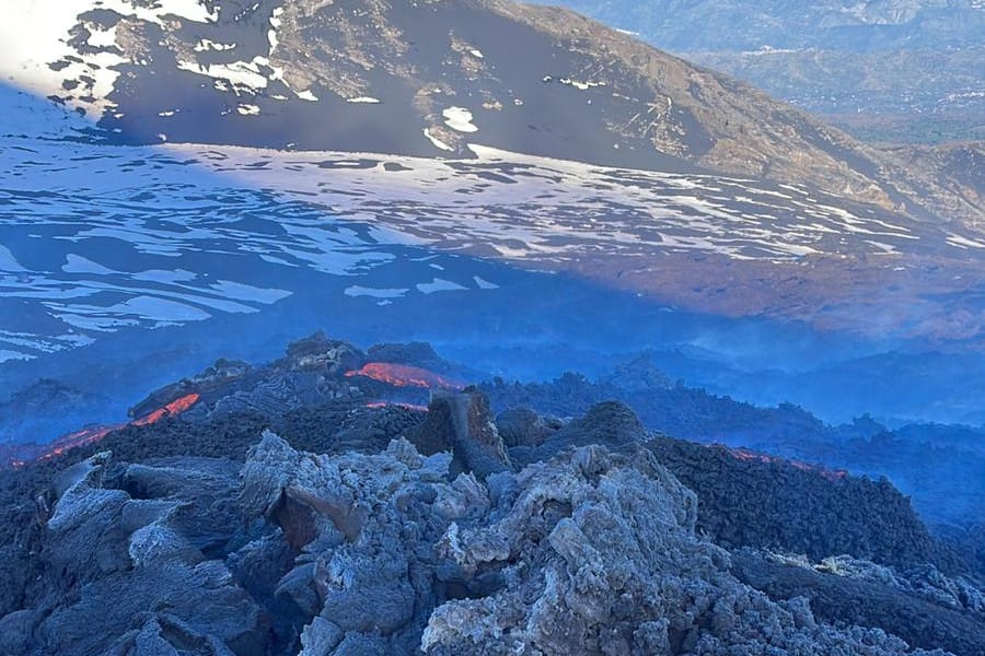 Il crinale innevato nell'ora blu, una traccia sale verso la vetta