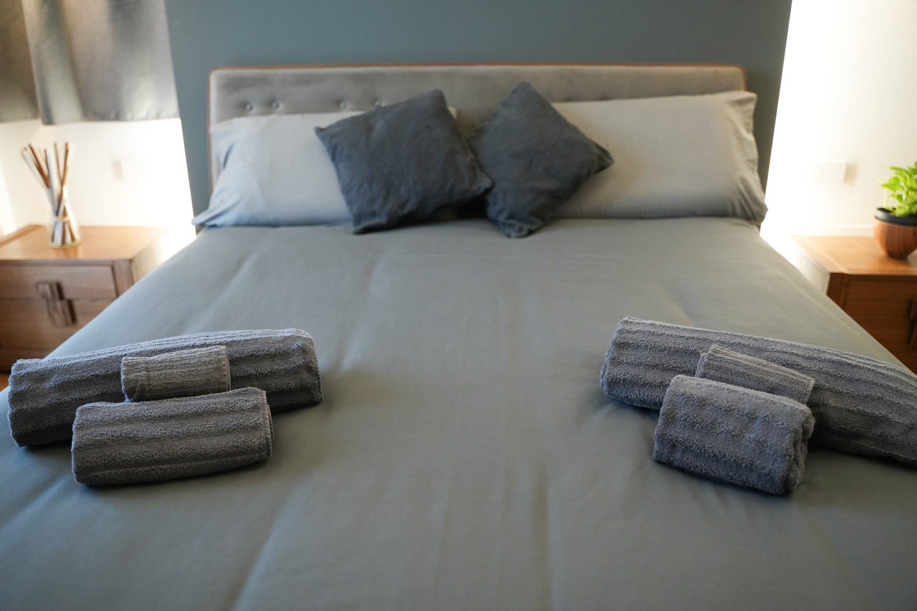Letto rifatto di fresco con cuscini e asciugamani arrotolati